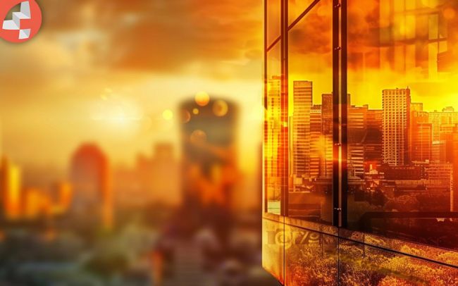 Sonnenuntergang über der Stadt mit reflektierenden Glasfenstern