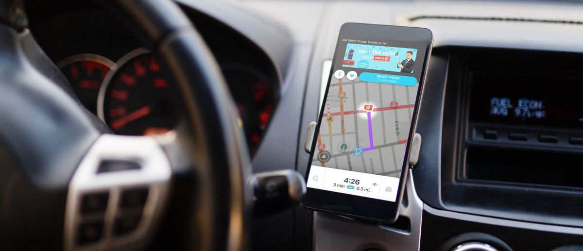 Navigations-App auf Smartphone im Auto-Halter.