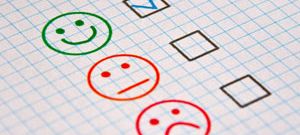 Checkbox mit drei Gesichtern: lächelnd, neutral, traurig, Häkchen bei lächelnd.