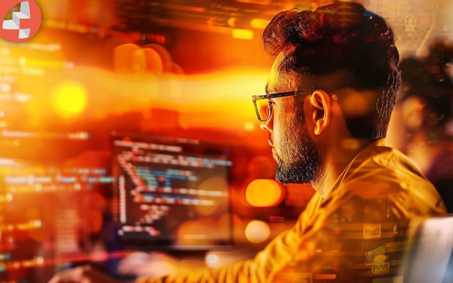 Programmierer arbeitet an einem Computer mit Code auf dem Bildschirm.