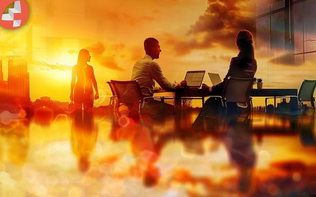 Menschen bei einer Besprechung vor einem Sonnenuntergang im Büro.