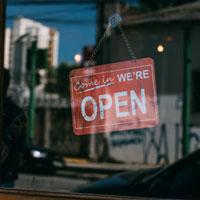 Geschäftstür mit Come in, we're open-Schild